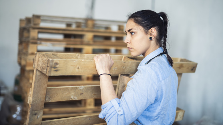 A woman works with wood pallet