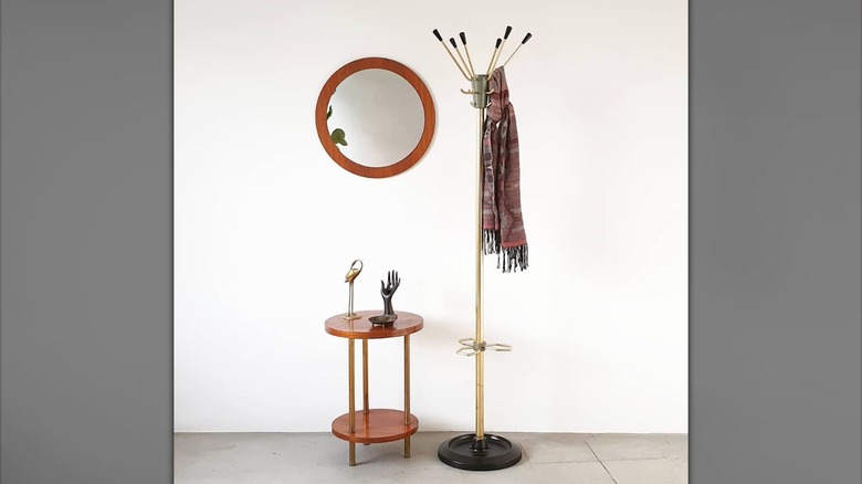 Coat rack beside mirror and table