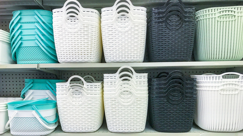 Plastic laundry baskets on a shelf at a store.