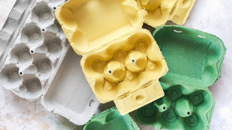 A pile of empty egg cartons on a countertop