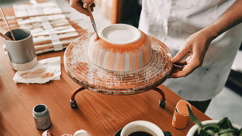 A person paints a bowl.