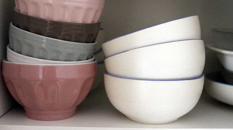 A cabinet is full of simple bowls.