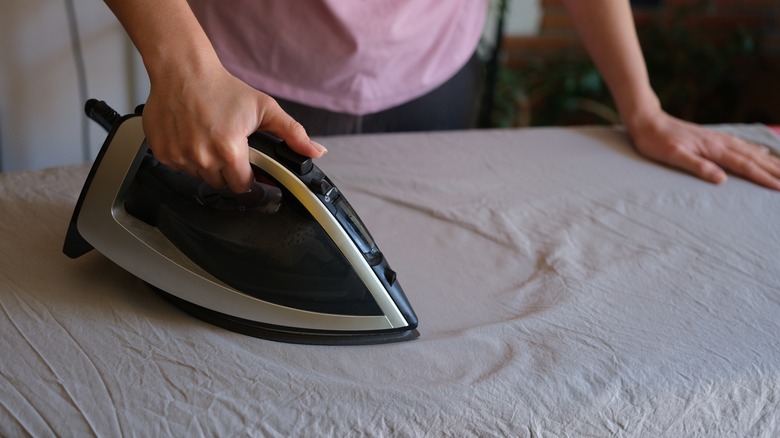 Woman ironing on a large ironing board