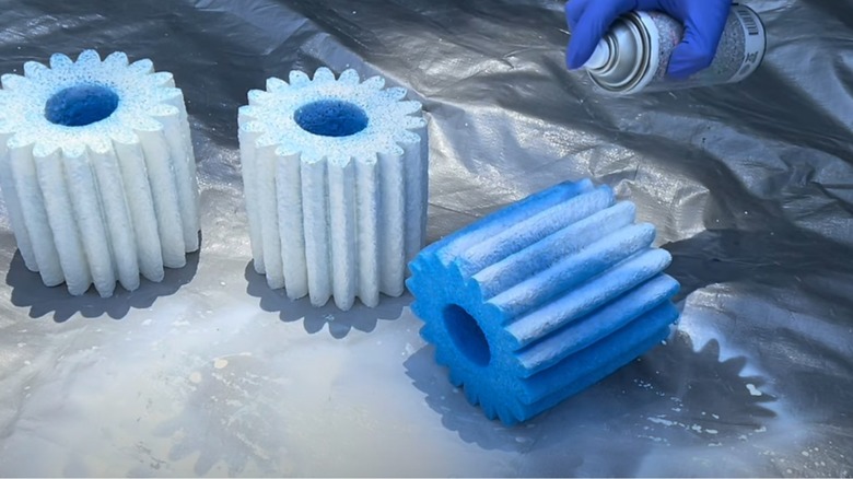 Person spray painting pool noodle boosters