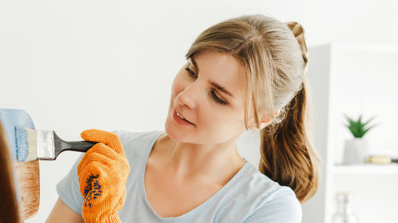 Woman painting a wooden object