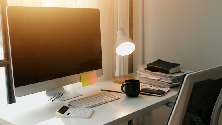 Desk with office supplies scattered on top