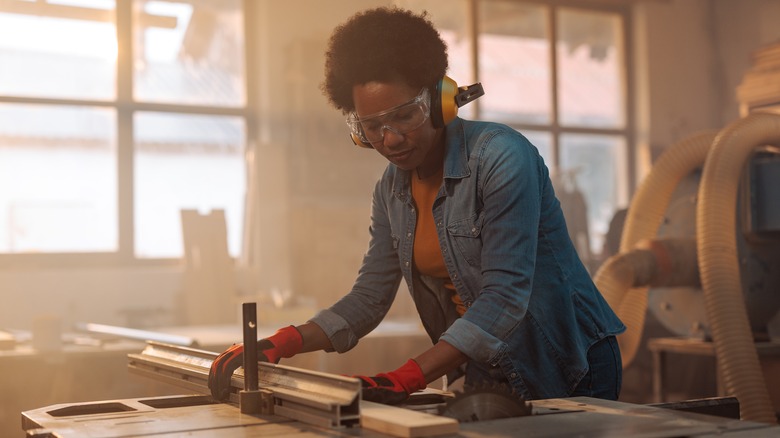 person cutting with table saw