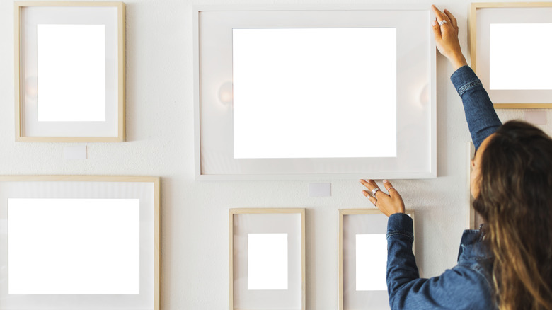 Woman looking at picture frames