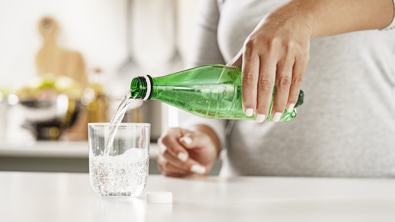 Pouring soda into glass from bottle