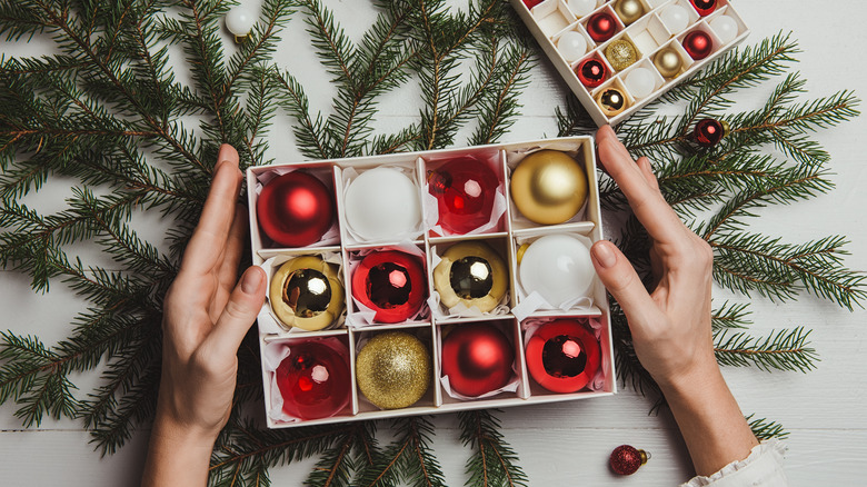 Ag box of red, white, and gold Christmas ornaments.