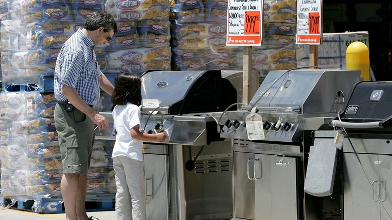 People shopping for a grill