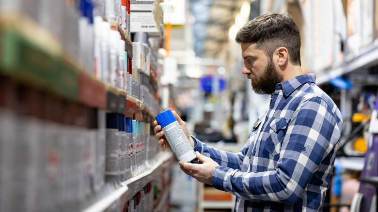 Person buying spray paint in shop