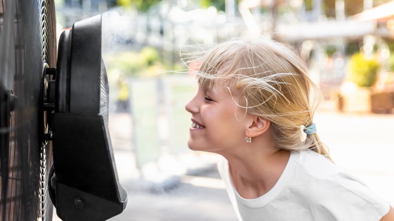 Girl using a misting fan 