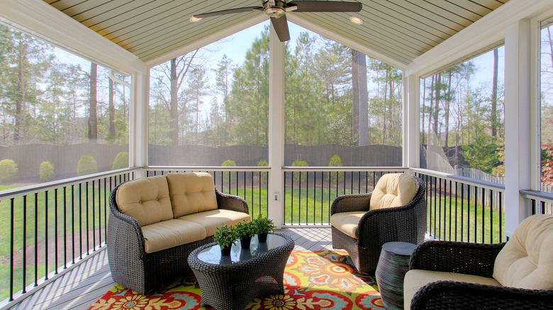 A conservatory overlooks a screened outdoor porch