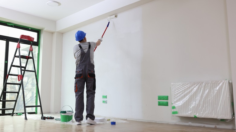 painting wall with extended paint roller