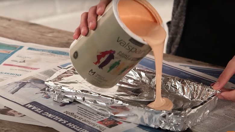 pouring paint in foil-covered tray