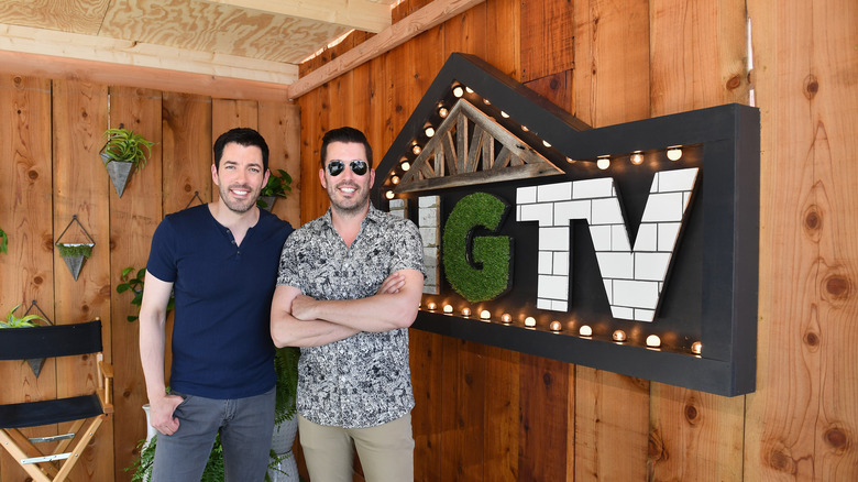 The Property Brothers in front of an HGTV sign