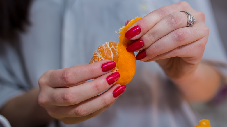 person peeling oranges