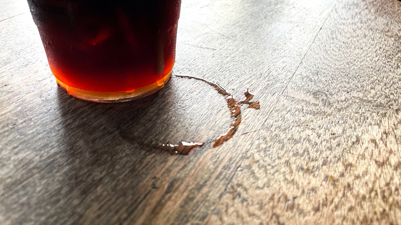 A glass leaves ring marks on a wood table