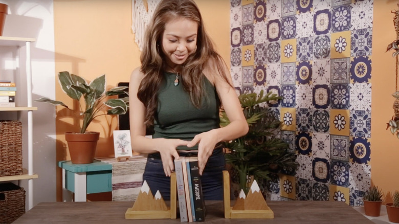 pretty young woman making mountain bookends