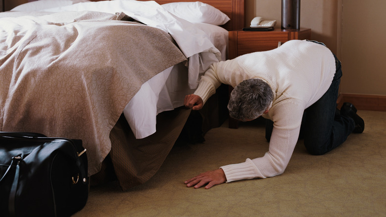 Man looking under bed