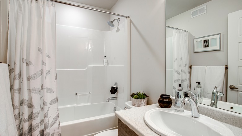 Black and white bathroom with low hung shower curtain