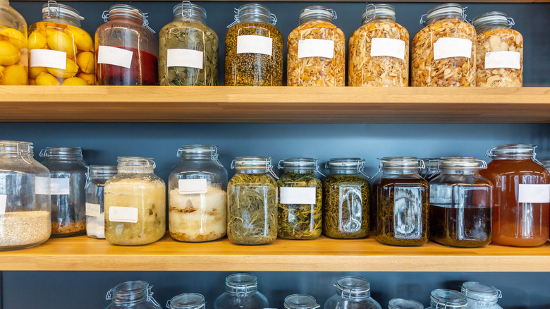 Rows of labeled mason jars on shelves in a pantry