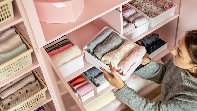 woman holds clothing storage container