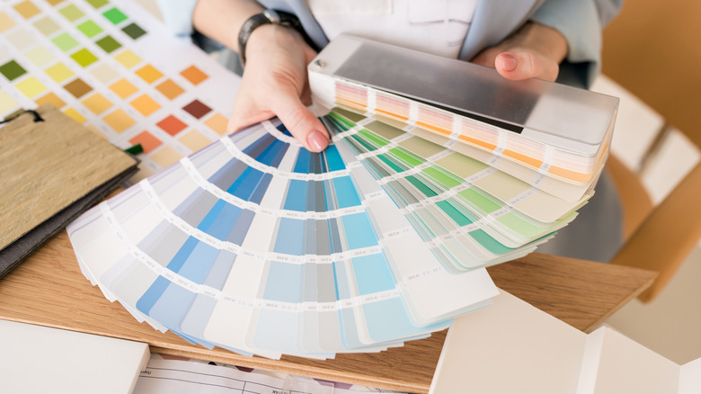 Person holding stack of paint swatch cards