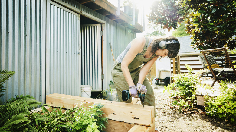 Woman building custom raised garden beds.