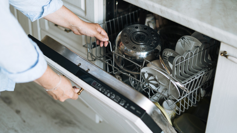 A person is opening up their dishwasher