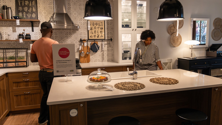 A couple looking through an IKEA kitchen with a marble countertop