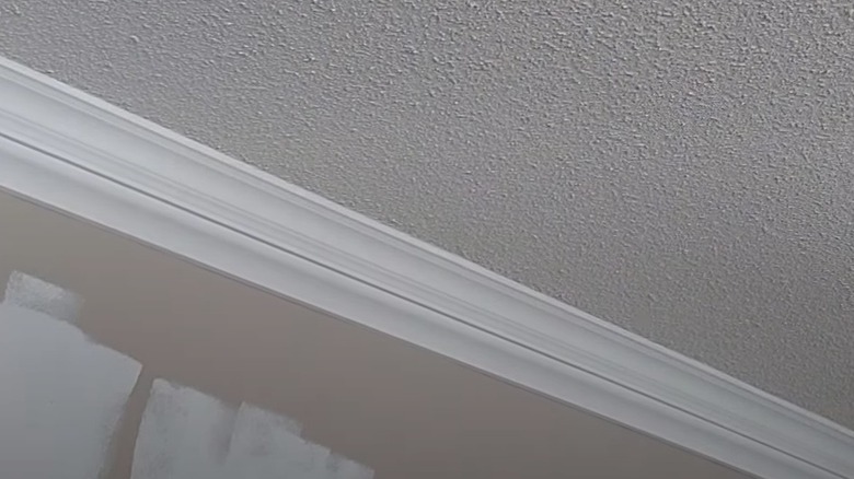 Crown molding is added to a room with a popcorn ceilings