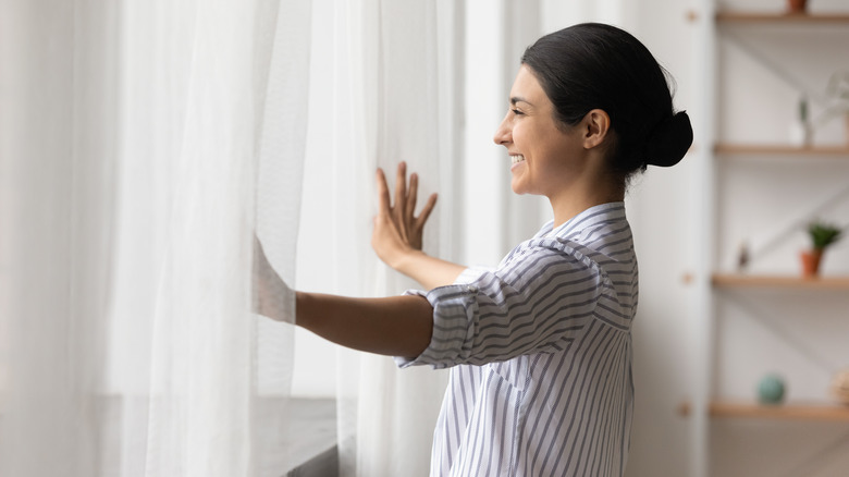 woman smiling while facing window