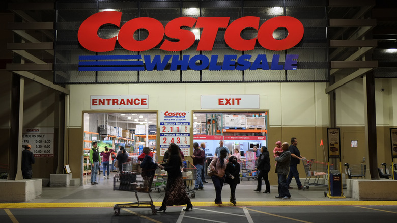 A photo of people walking in and out of the Costco entrance