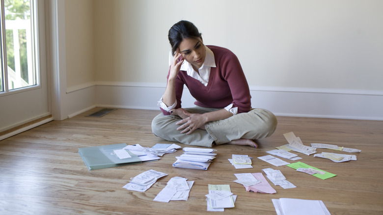 woman looking at pile of bills