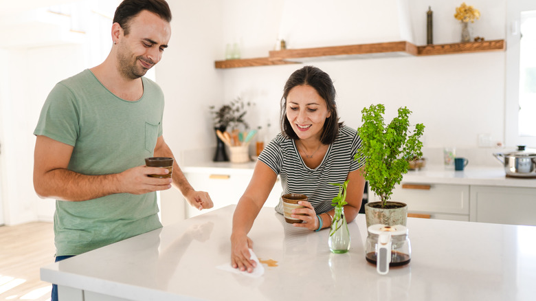 couple wiping coffee off countertops