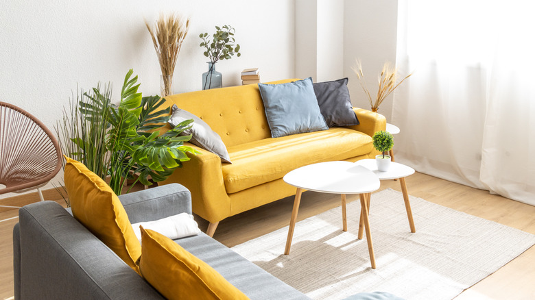 Pops of yellow in a living room through the couch and pillows