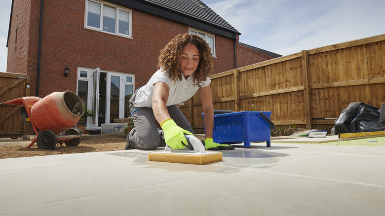 Woman grouting tile floor