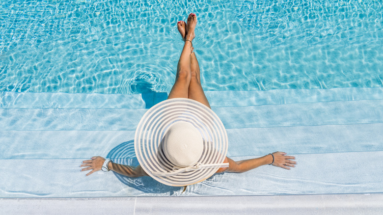 Person lounging on pool steps