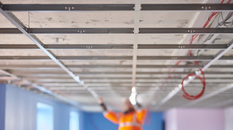 Person installing suspended ceiling