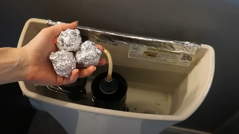 Person holding foil over tank