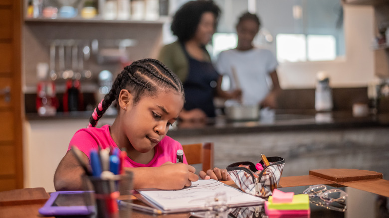 Child coloring at kitchen table