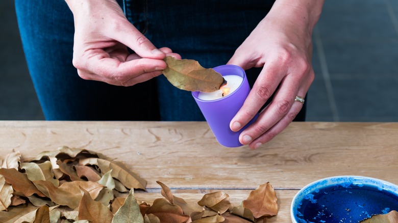 Woman lighting herbs with candle