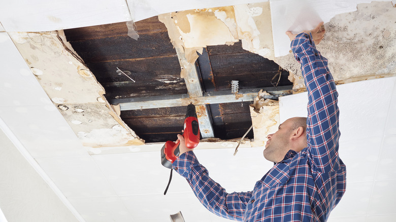 Man fixing damaged roof