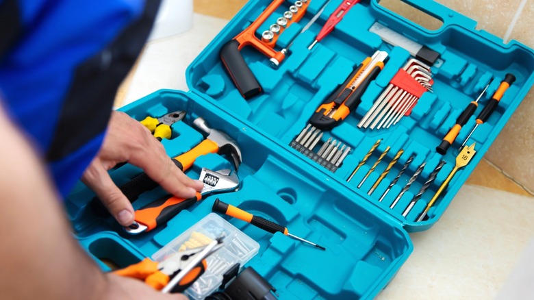 person opening blue tool case