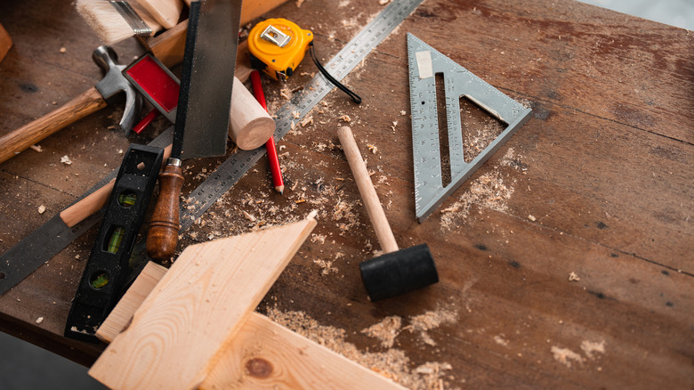 A collection of carpenter's tools on a wood work bench