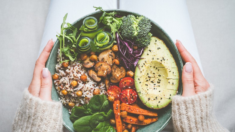 Person holding a bowl of vegetables