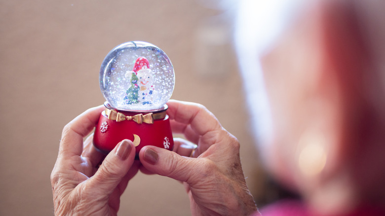 Someone holding a small snowglobe