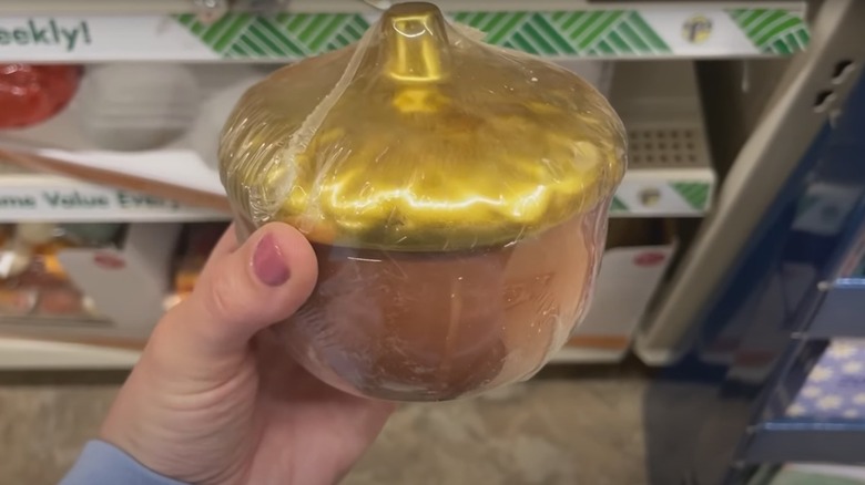 Hand holding wrapped acorn jar